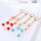 Gold-tone crystal tassel earrings with red and blue crystal drops, set of pairs