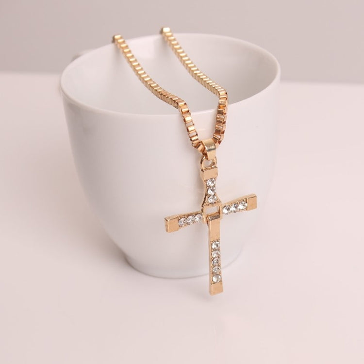Gold rhinestone cross pendant necklace on a white display bust