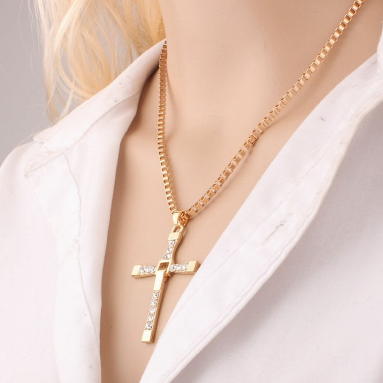 Gold rhinestone cross pendant necklace close-up at the collar