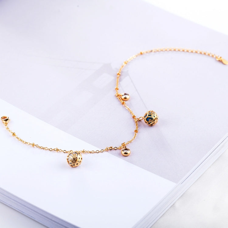 Gold-plated bracelet with blue zircon round bead and dangling pendant charms