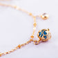 Close-up gold-plated bracelet charm with blue zircon set in round filigree bead