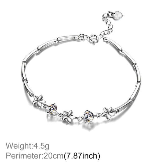 Silver-tone frangipani charm bracelet with flower accents and round clear stones