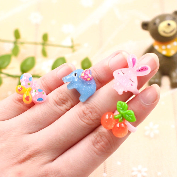 Hand holding colorful resin kids animal character rings with flower and bow charms
