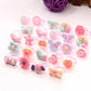 50 frosted resin children’s rings featuring pastel flowers, hearts, bows, and animal designs