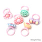 Close-up of pastel frosted resin children’s rings with flower and bow details