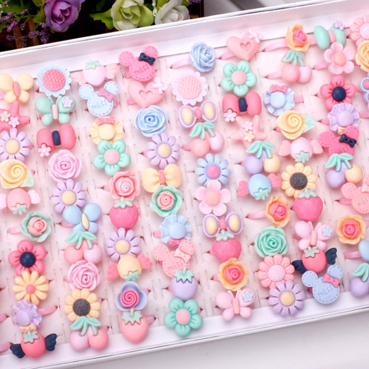 Tray filled with frosted resin kids rings in pastel flower, heart, bow, and animal shapes