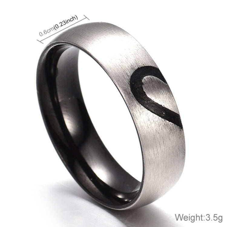 Silver-tone ring with black heart motif on brushed metal surface