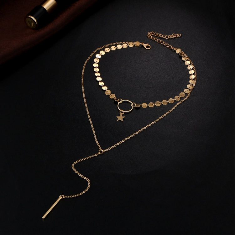 Gold long pendant necklace with star charm, oval ring clasp, and bar tassel