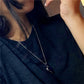 Heart pendant necklace worn on a neckline with silver-tone chain