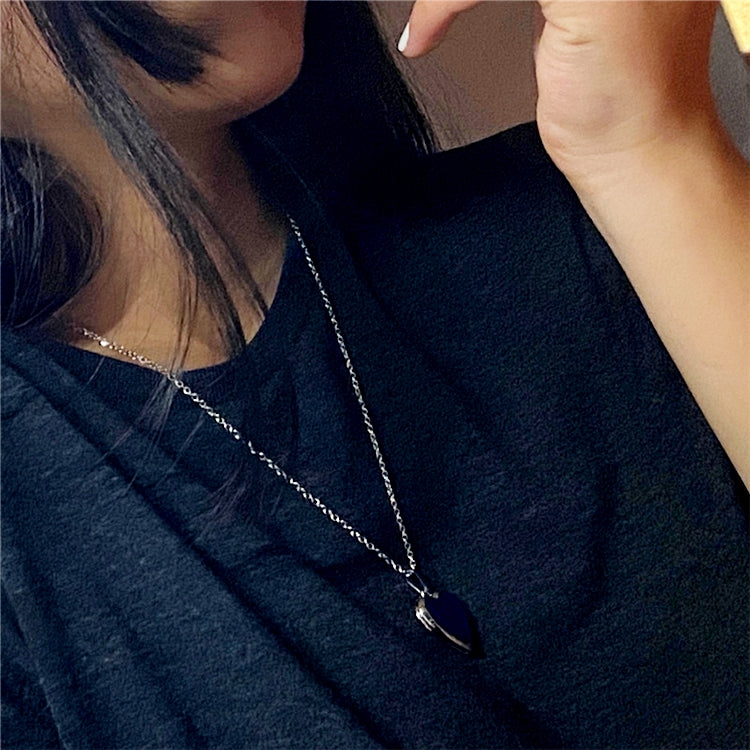 Heart pendant necklace worn on a neckline with silver-tone chain