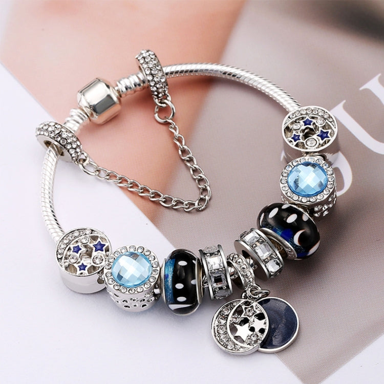 Silver-tone bracelet with blue crystal beads, dark enamel beads, and star moon charm discs