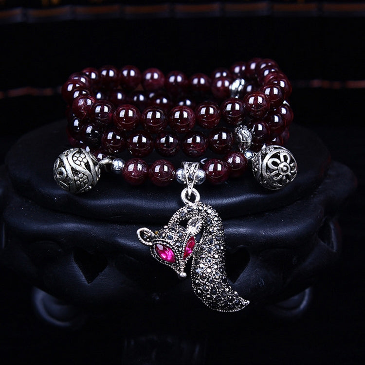 Dark maroon beaded bracelet with silver cat-like charm and round bead spacers