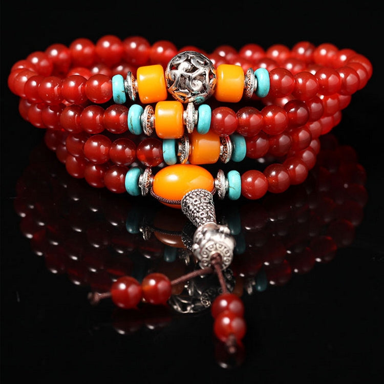 Red beaded bracelet with orange and turquoise accent beads and elephant charm