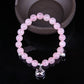 Pink beaded bracelet with silver cat-face charm, elastic stretch band