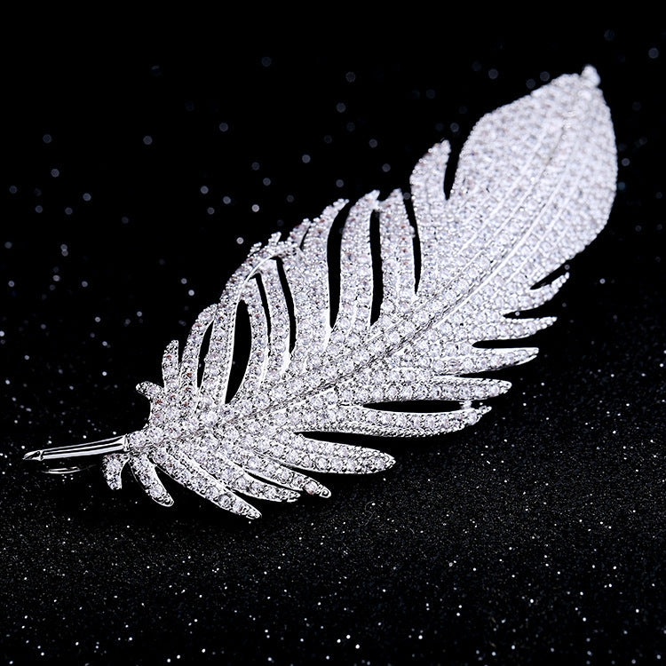 Jeweled feather brooch with sparkly texture and pin stem