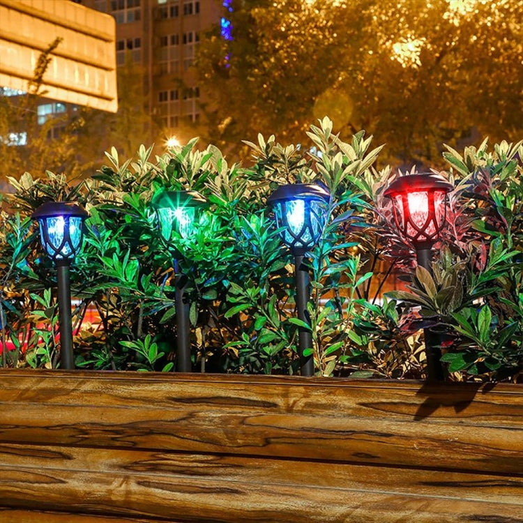 Colorful glowing solar stake lantern lights among green plants