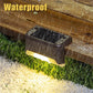 Black solar outdoor step light with warm beam, shown in heavy rain and water droplets.