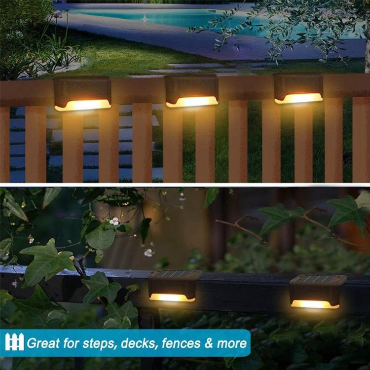 Warm-glow solar fence step lights along vertical posts, outdoor garden walkway at night.