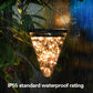 Solar conical pendant garden lamp glowing warm through clear cone in rainy scene