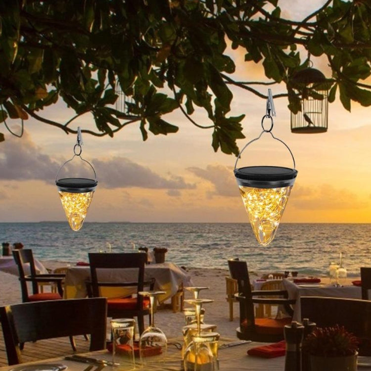 Solar conical garden pendant lights hanging outdoors at sunset, warm glow