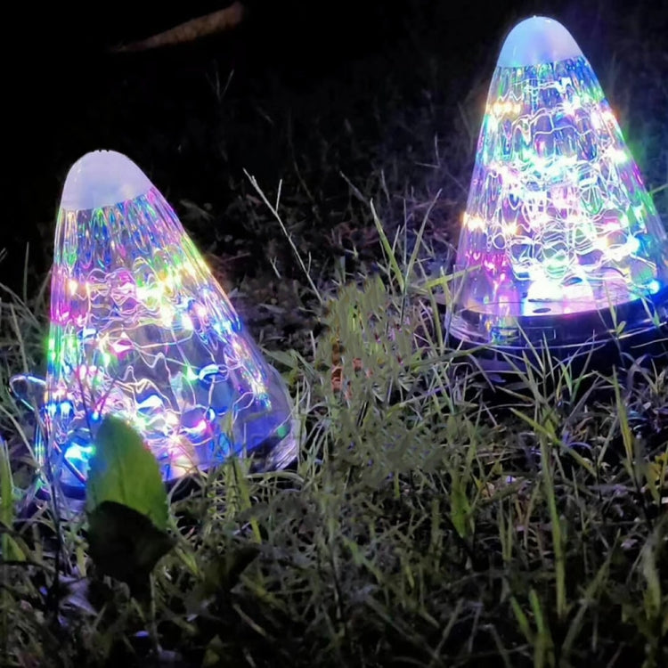 Solar conical garden lamps glowing multicolor through clear cone shades in grass