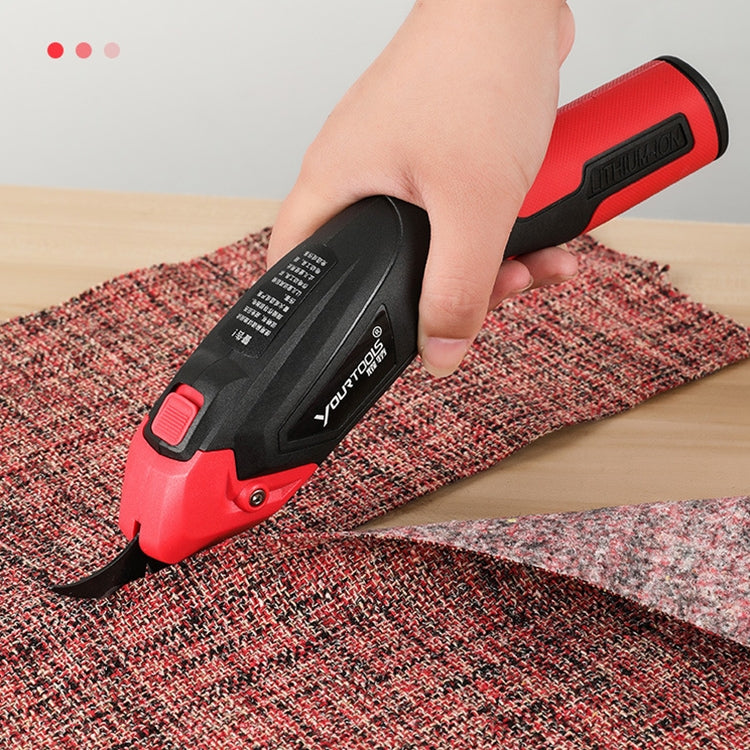 Red and black electric scissors cutter head cutting patterned fabric