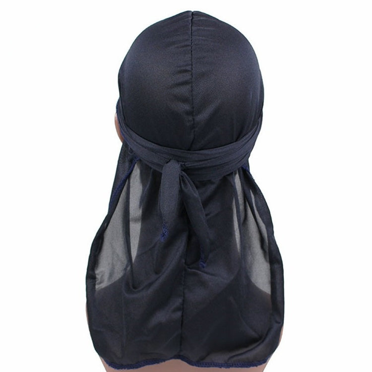 Dark long-tailed headscarf hat with gathered fabric and tied back tails
