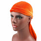 Orange velvet turban cap with wrapped band and long trailing tail