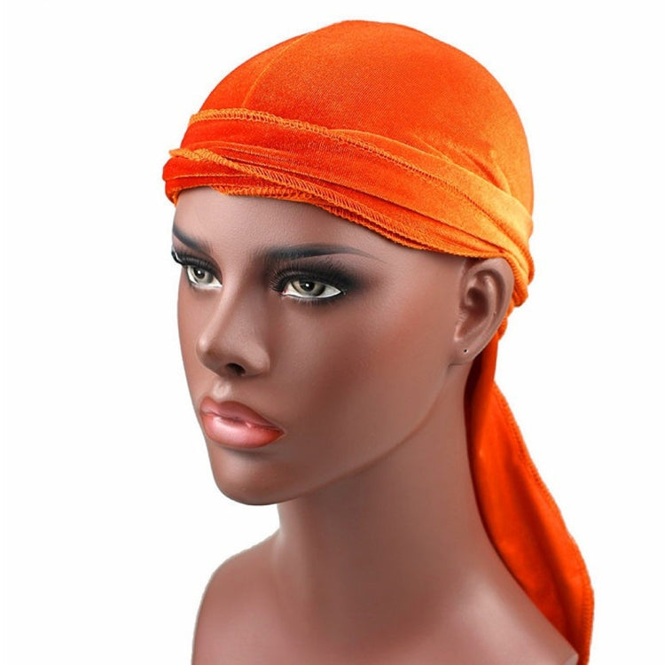 Orange velvet turban cap with wrapped band and long trailing tail
