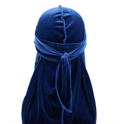 Blue velvet turban cap with long draped tail and tied bow at the front