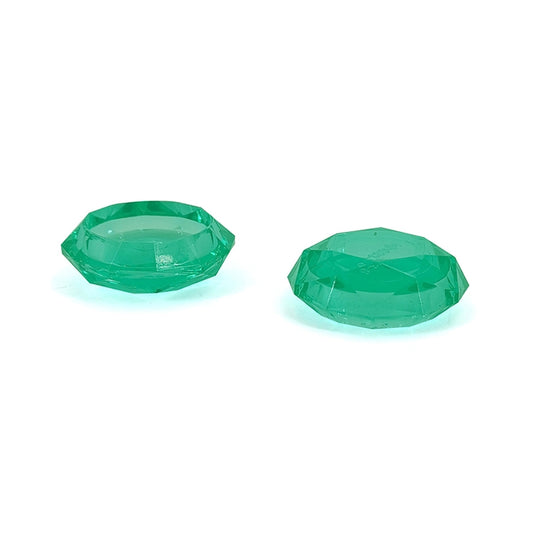 Two green faceted game controller grip caps, shown from the side.