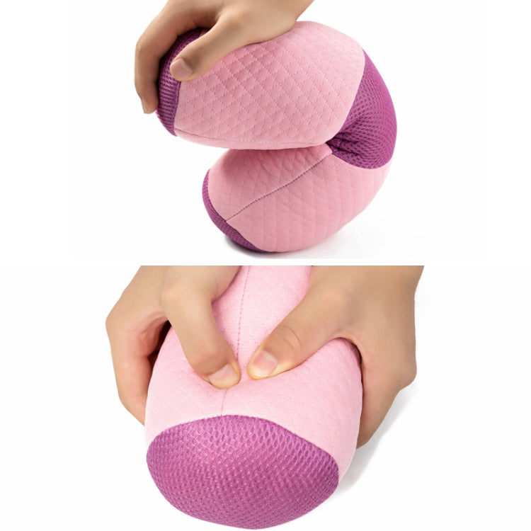 Pink yoga bolster pillow with purple mesh edges, held and folded for storage