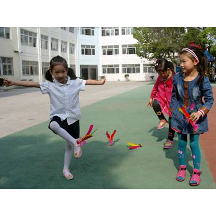 Children playing with colorful feather shuttlecocks on an outdoor court