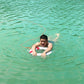 Person holding a white foam swimming ring with blue accents in a pool