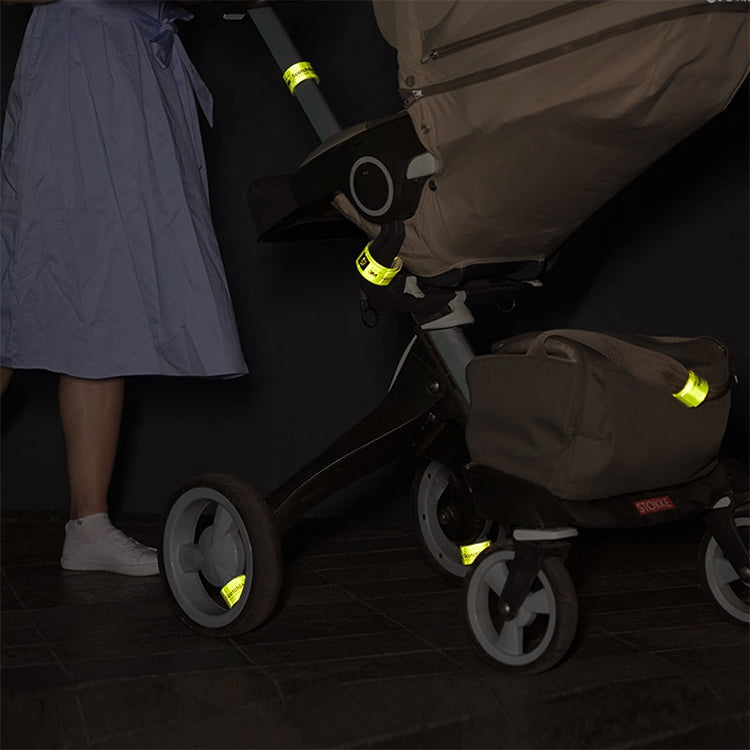 Reflective wristbands attached to stroller handle, neon green reflective strips