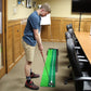 Green and black indoor mini putting mat on floor with practice push rod