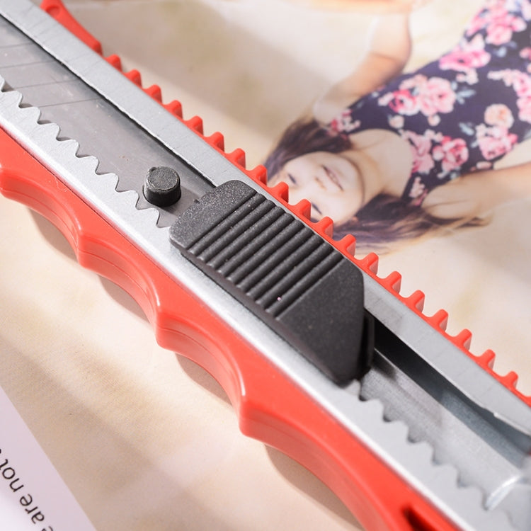 Close-up of red paper cutter knife showing serrated blade and black slider knob