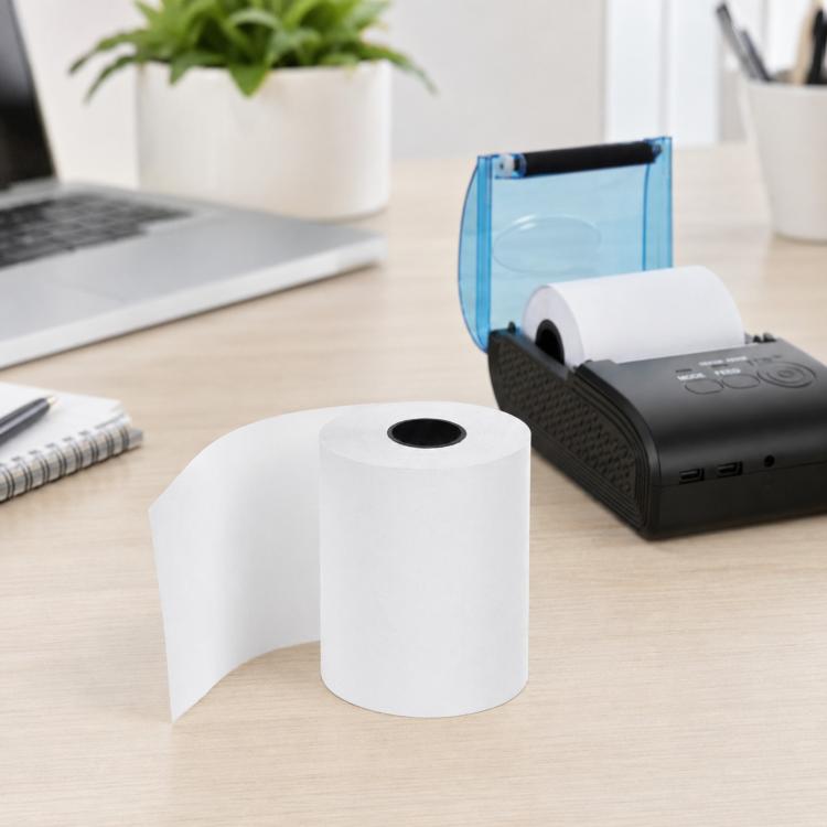 White thermal paper roll in a 0.03mm thickness, on a desk near a printer