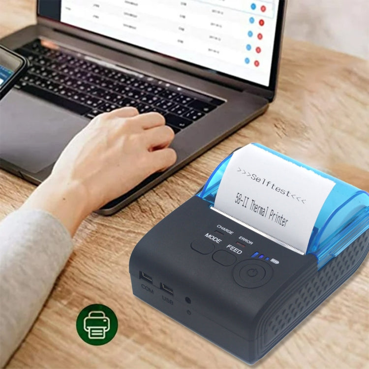 Thermal paper roll in a printer while a user operates a laptop keyboard