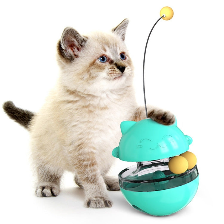 Turquoise cat treat tumbler toy ball with dangling cord, shown with a kitten nearby
