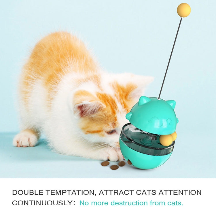 Turquoise cat treat tumbler toy ball with dangling cord, shown with a kneeling kitten