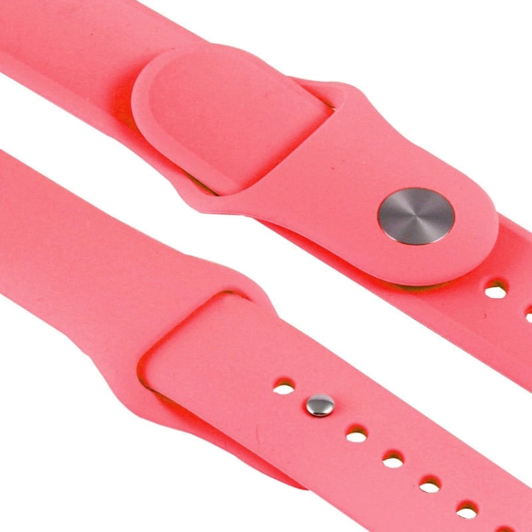 Pink rubber watch band closeup showing metal keepers and pin-and-tuck eyelets