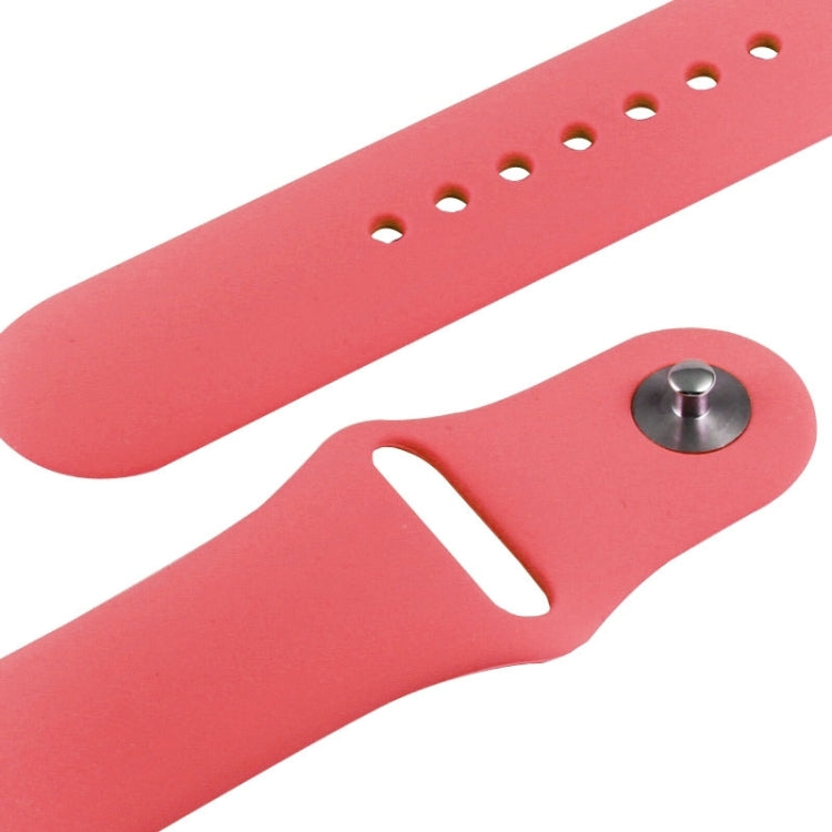 Pink rubber watch band detail with row holes and brushed metal connector
