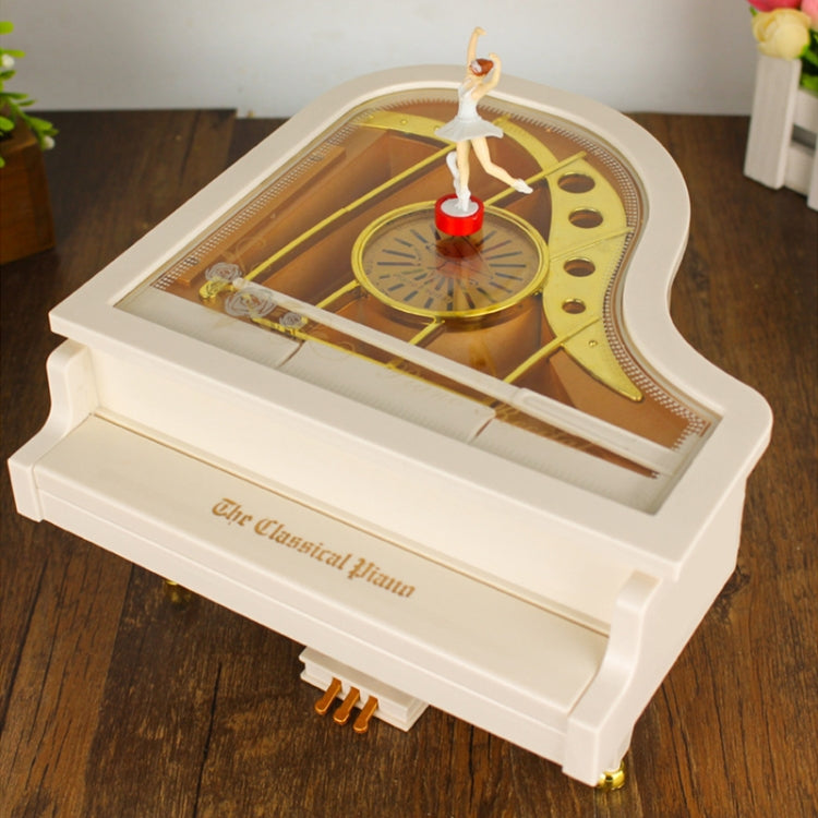 White mechanical music box piano with ballerina dancer over golden mechanism