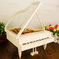 White music box piano with open lid and golden interior mechanism panel