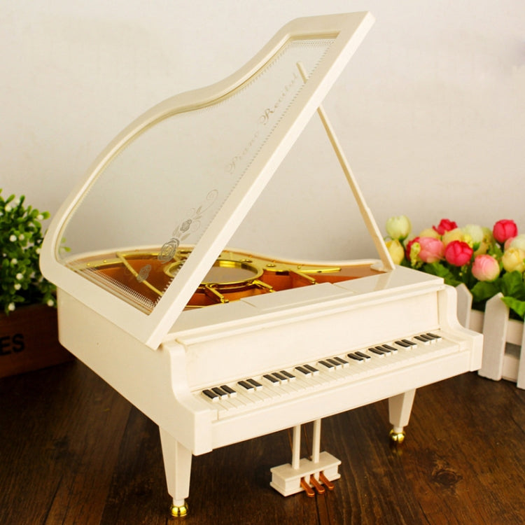 White music box piano with open lid and golden interior mechanism panel