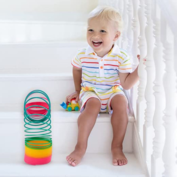 Rainbow spring coil ring toy with child playing on stairs, multicolor stacked coil