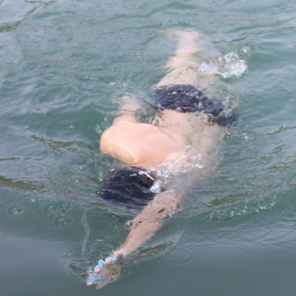 Swimmer wearing silicone webbed hand flippers in open water for training