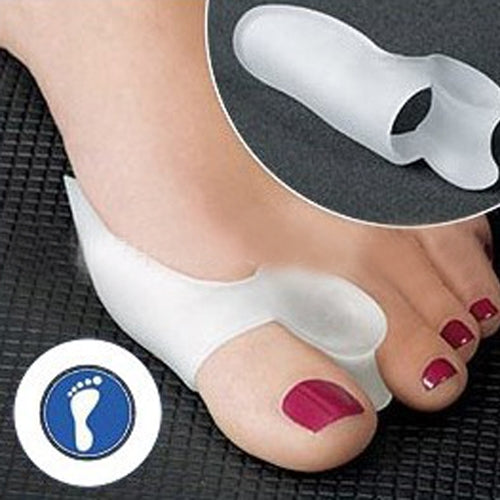 Pair of white silicone toe separator braces on toes, open toe pad