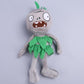 Plush zombie doll in green ragged dress with leaf-like head tuft and stitched face